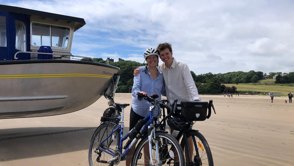 Kathi und Eli stehen vor am Strand vor einem Motorboot