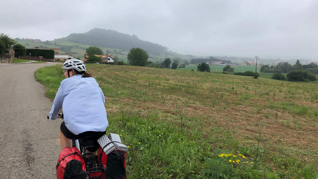 Kathi radlt auf einem Feldweg, im Hintergrund dichter Nebel