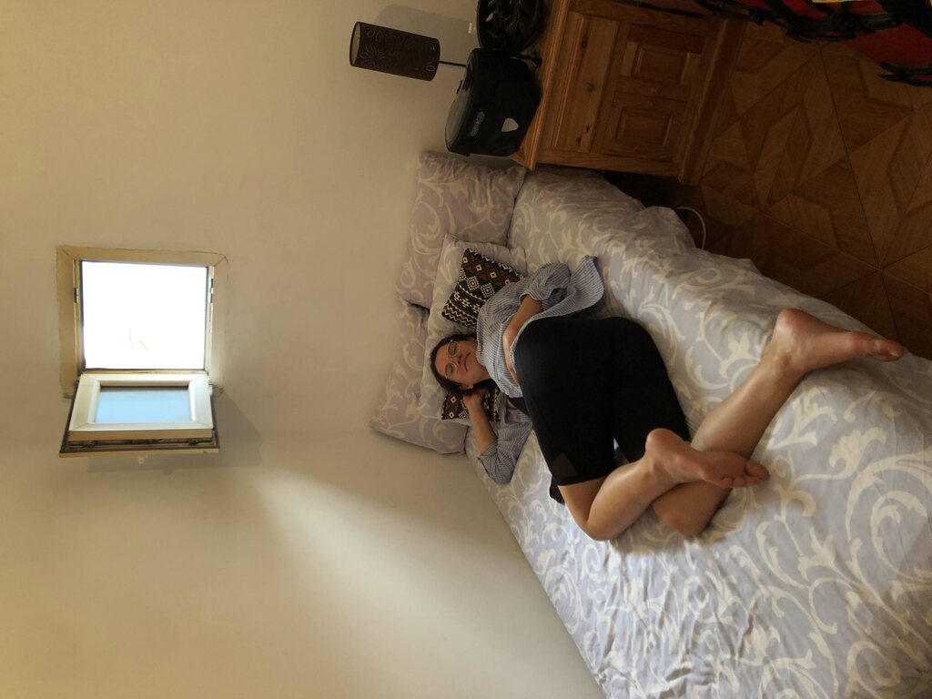 Kathi liegt auf einem schmalen Bett in einem kleinen Zimmer mit winzigem Fenster