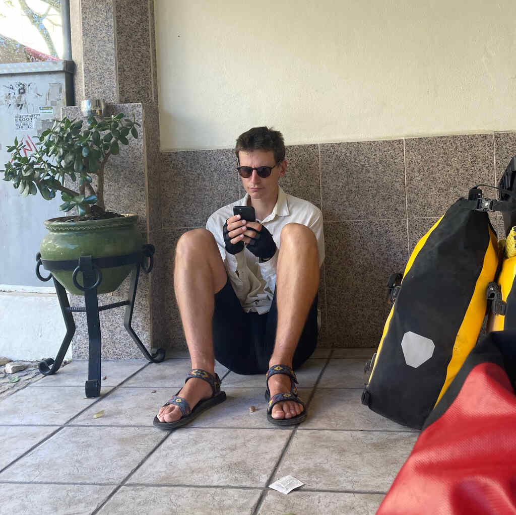 Eli sitzt neben dem Eingang zur Unterkunft in Albufeira