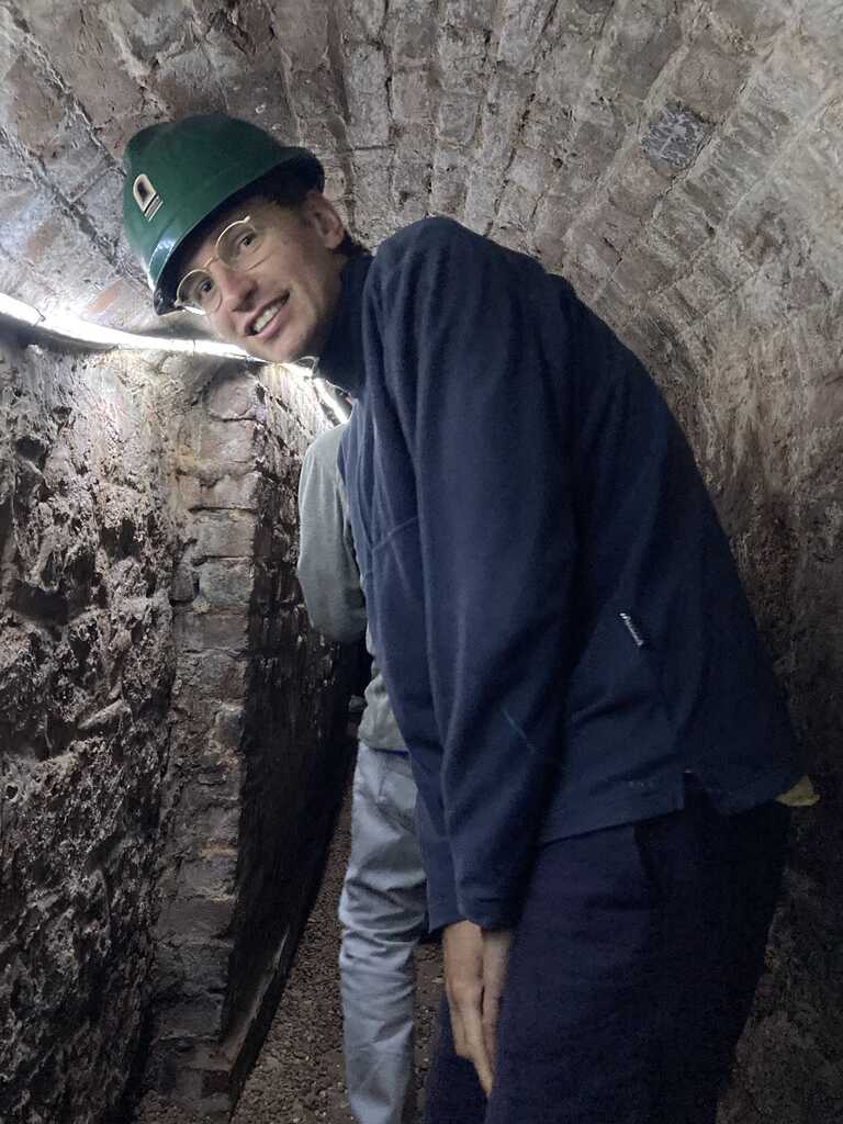 Eli mit Plastikhelm in einem engen Tunnel