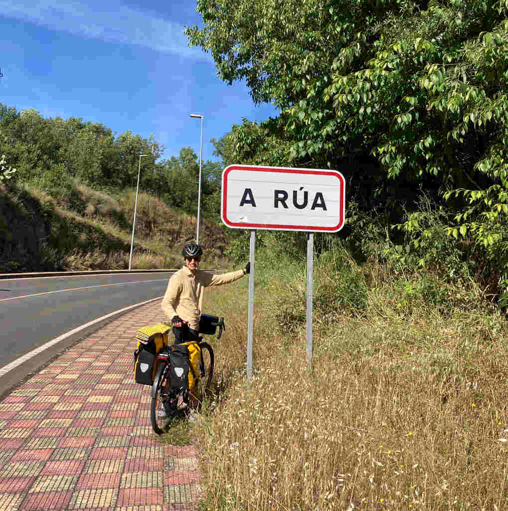 Eli steht am Ortsschild von A Rúa