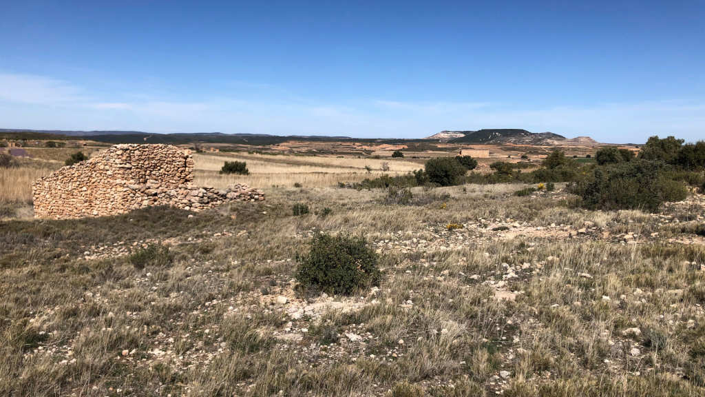 Weite Landschaft mit zerfallenem Steinhaus