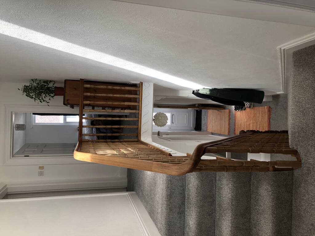 Eine schmale Treppe mit Holzgeländer und Teppichboden