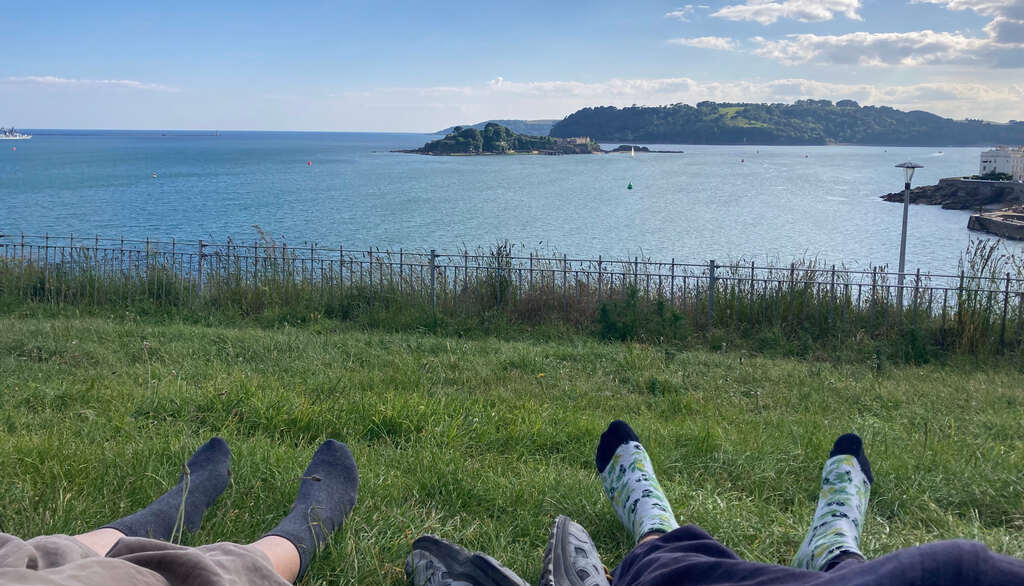 Füße und Socken von Kathi und Eli auf einer Wiese mit Blick übers Plymouth Bay