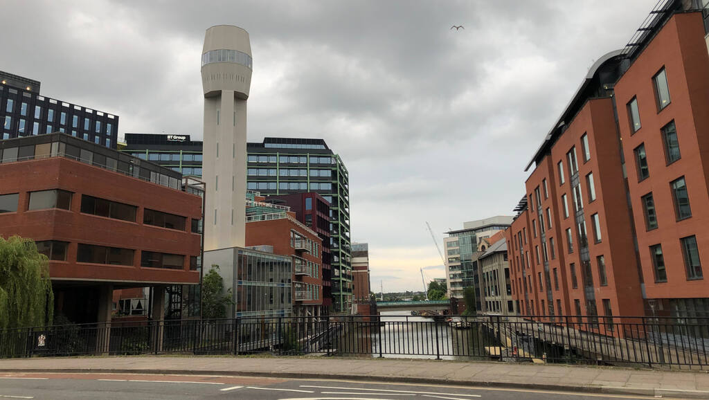 Ein weißer Turm über einem Kanal zwischen roten Backsteinhäusern