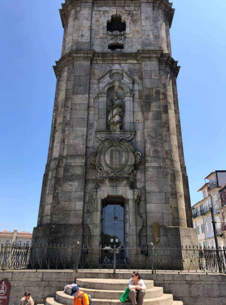Kathi sitzt am Fuße der Torre do Clérigos