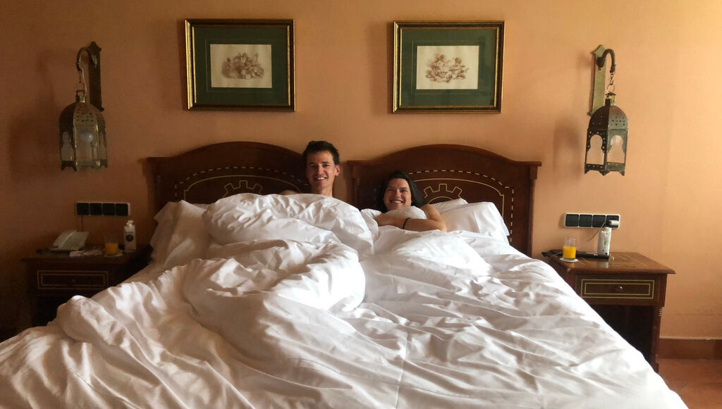 Kathi und Eli liegen im Bett ihrer Suite im 4 Sterne Hotel