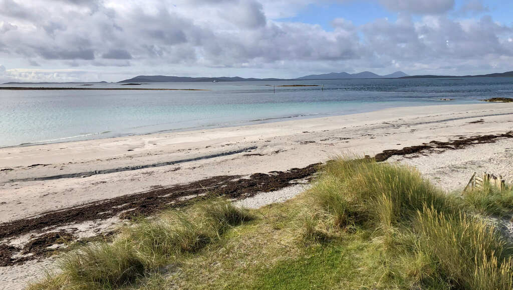 Ein weißer Sandstrand mit türkisblauem Wasser